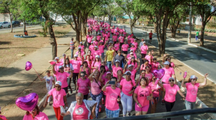 Mãos com fitas rosas juntos em uma corrida pela concientização do cancer de mama